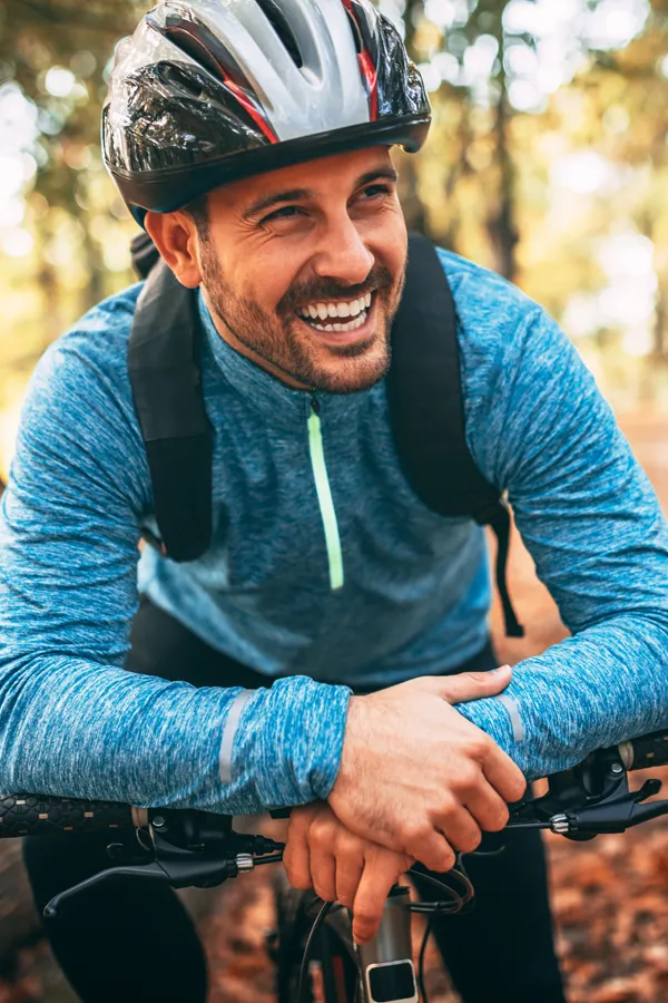 Adrenal-Hormone-Disorder-Treatment A smiling man getting ready for a cycling trip. Get treatment for adrenal hormone disorder from Guerda Johnson, FNP-C in Tyler East Texas Area.