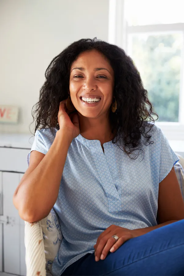 Digestive-IV-Therapy-Treatment A healthy, happy middle-aged black woman sitting in a sunlit room. Get IV Therapy for digestive health from Guerda Johnson, FNP-C in Tyler East Texas Area.