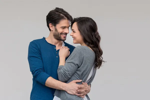 Erectile-Dysfunction-Doctor A man in a blue shirt embracing a woman in a gray shirt smiles due to his successful erectile dysfunction care from Guerda Johnson, FNP-C in Tyler East Texas Area.