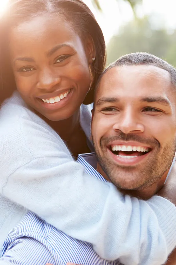 Erectile-Dysfunction-Treatment A woman riding on a man's back, both smiling due to help with erectile dysfunction from Guerda Johnson, FNP-C in Tyler East Texas Area.