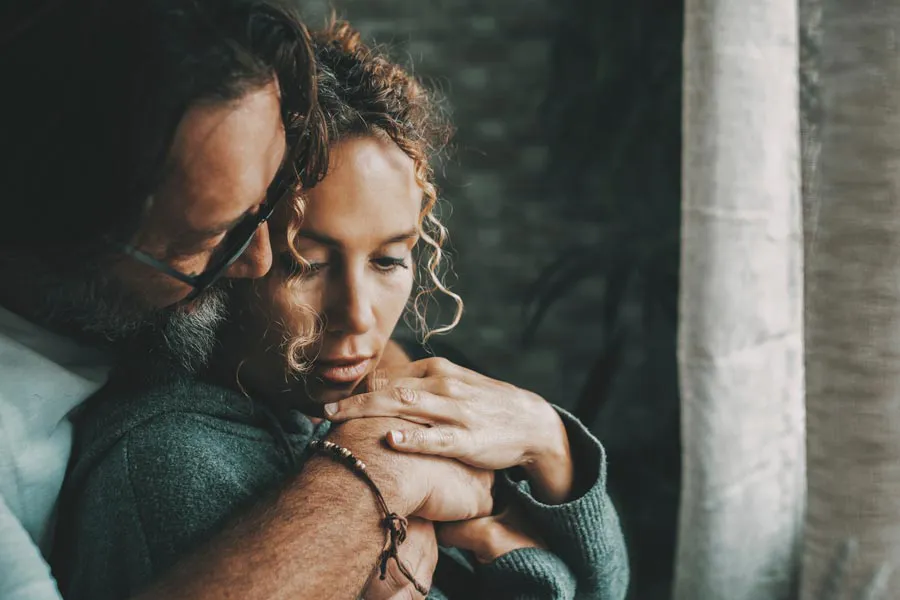 Functional-Psychiatry-Clinic A husband embraces his troubled wife. Schedule functional psychiatry treatment for mental health from Guerda Johnson, FNP-C in Tyler East Texas Area.