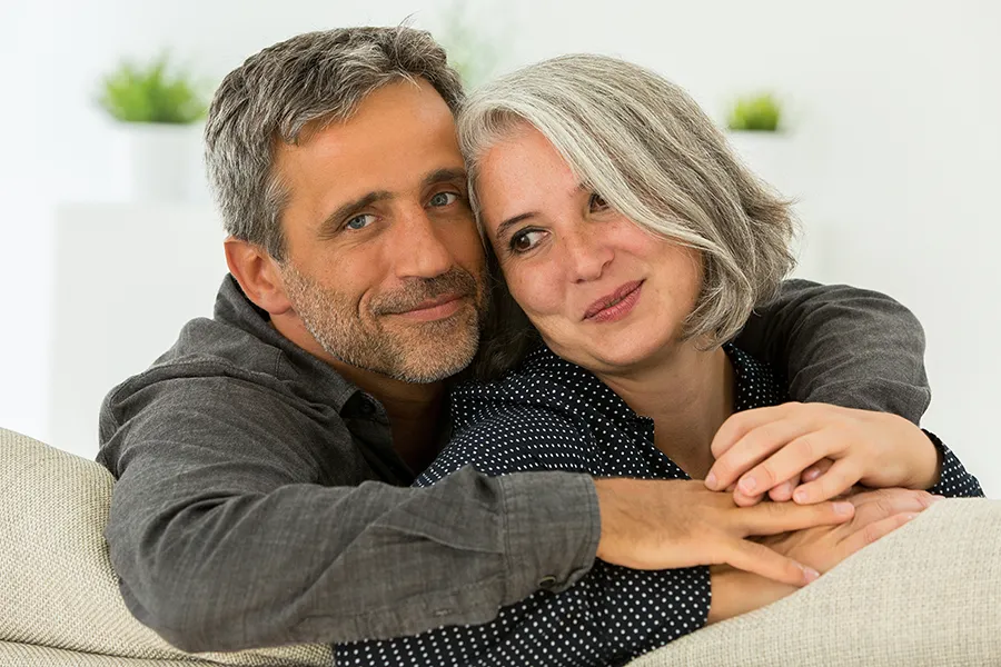 Hormonal-and-Vitality-Peptides-Clinic A middle-aged couple holding each other on the couch. Get Hormonal and Vitality Peptide Treatment from Guerda Johnson, FNP-C in Tyler East Texas Area.
