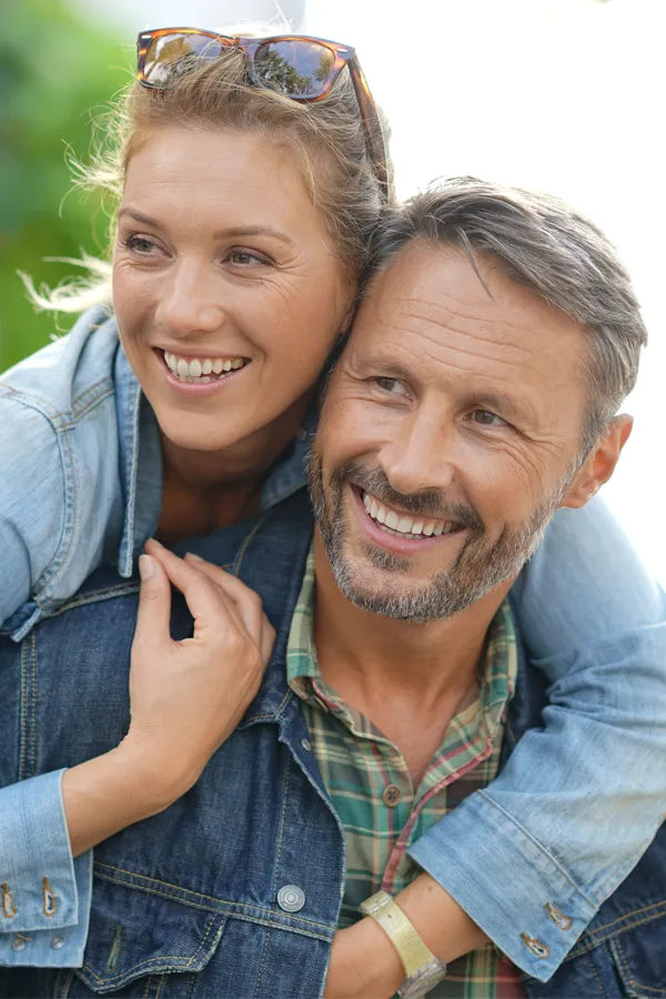IV-Therapy-for-Fatigue-and-Energy-Treatment A middle-aged couple embrace while on vacation. Get IV Therapy for Fatigue and Energy from Guerda Johnson, FNP-C in Tyler East Texas Area.