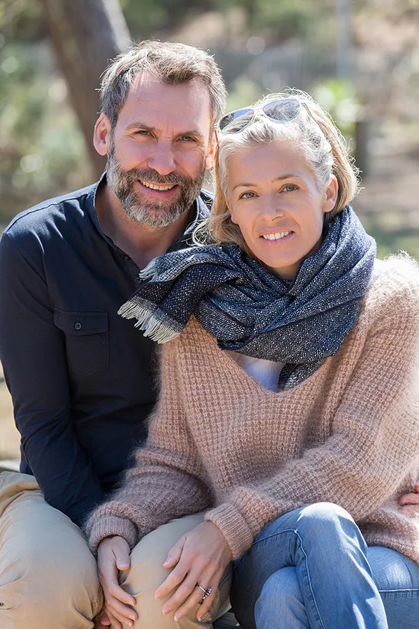 Inflammotory-Bowel-Disease-IBD-Treatment Happy middle-aged couple outdoors wearing cozy fall clothes, smiling calmly. Guerda Johnson, FNP-C is a compassionate IBD specialist in Tyler East Texas Area supporting long-term gut health and symptom relief through functional medicine.