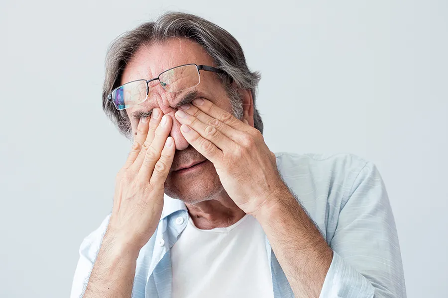 Migraine-Clinic Get migraine relief with Guerda Johnson, FNP-C's functional medicine for migraines treatment in Tyler East Texas Area, represented by an older man rubbing his eyes due to head pain.