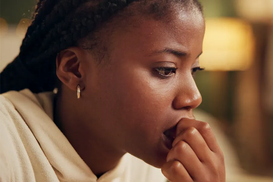 Mood-Imbalance-Clinic A black woman feeling stress bites her nails and looks withdrawn. Get treatment for mood imbalances and stress from Guerda Johnson, FNP-C in Tyler East Texas Area.