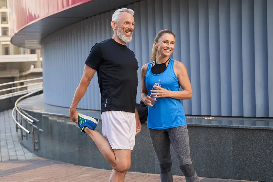 Peptides-for-Healing-and-Recovery-Doctor A middle-aged couple happily stretch and prepare for exercise after receiving effective peptide therapy for healing and recovery from Guerda Johnson, FNP-C in Tyler East Texas Area.