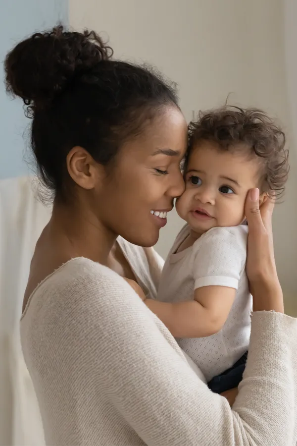 Postpartum-Hormone-Imbalance-Treatment A black woman happily touches her forehead to her infant's head. Get treatment for postpartum hormone imbalance from Guerda Johnson, FNP-C in Tyler East Texas Area.