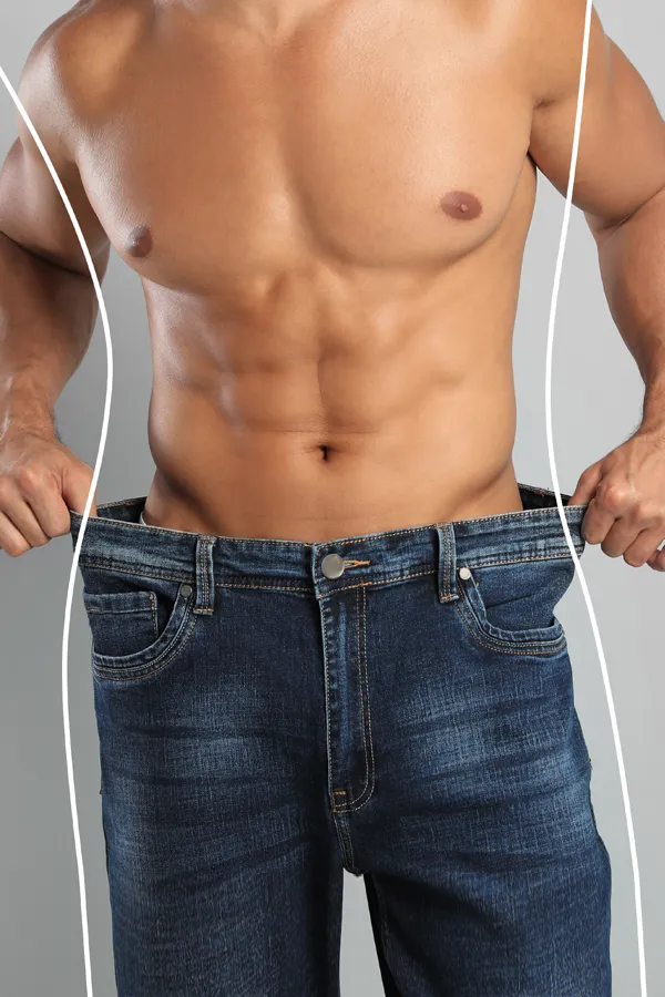 Semaglutide-Weight-Loss-Treatment A strong shirtless man in jeans holds the waistlines of his too-big jeans to show the success of semaglutide weight loss from Guerda Johnson, FNP-C in Tyler East Texas Area.