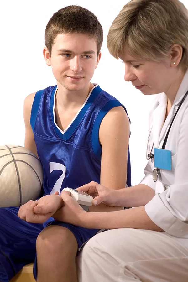 Crohns-Disease-Treatment A woman with a white blouse an jeans drinking tea in her kitchen, smiling after getting treatment for Crohn's Disease from Guerda Johnson, FNP-C in Tyler East Texas Area.