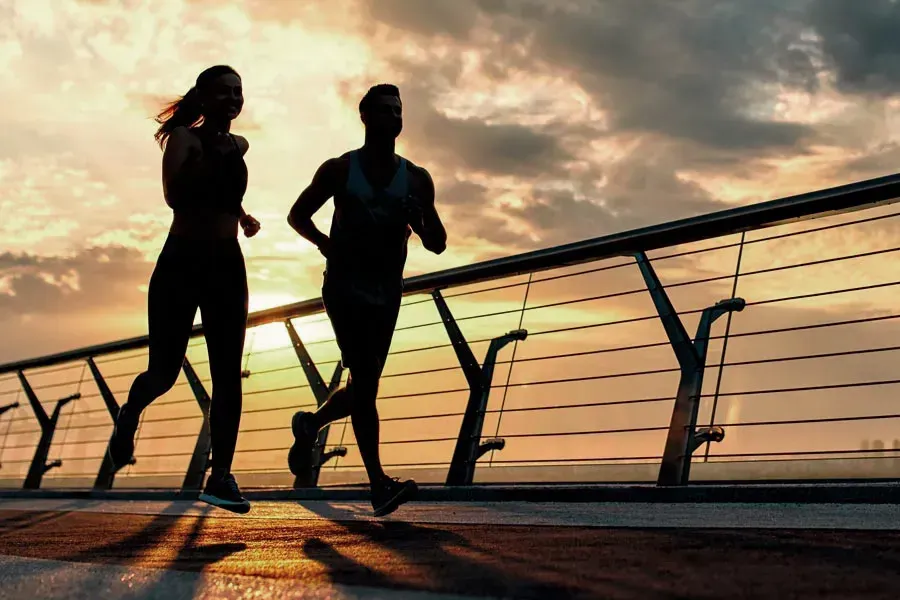 Weight-Loss-Medication-Clinic A couple seen by silhouette running at sunrise. Get Weight Loss Medication treatment from Guerda Johnson, FNP-C in Tyler East Texas Area.